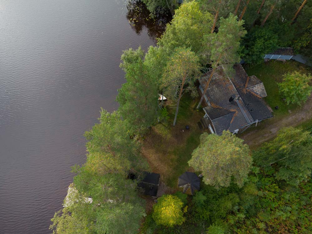 Ilmakuva Kulmala-mökistä puiden keskellä Kannonjärven rannalla.