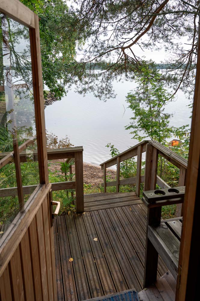 Mökkiterassilta avautuu näkymä Kannonjärvelle ja puiden lomasta näkyvälle hiekkarannalle.